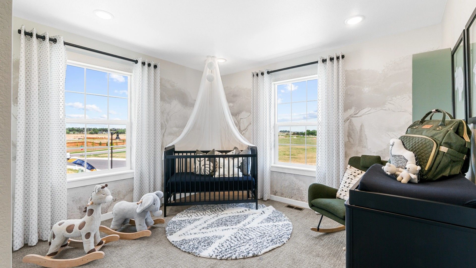 Timnath Lakes nursery features designer crib, plush rocking toys, and panoramic windows for serene views.