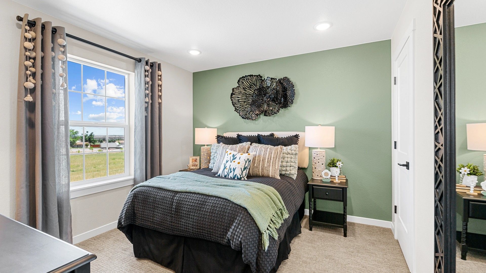 Elegant bedroom features a chic green accent wall and designer decor. Abundant natural light enhances the Timnath Lakes ambiance.