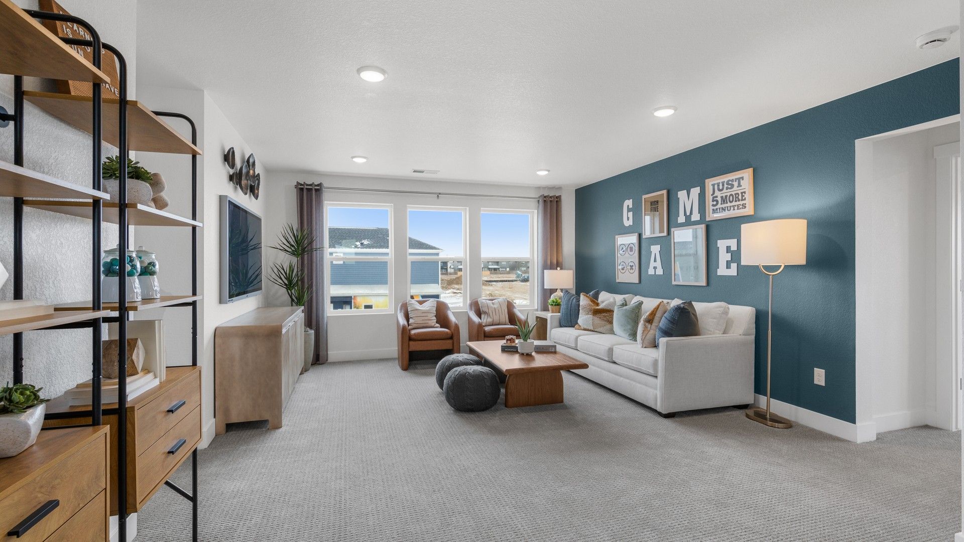Experience luxury with expansive windows, chic teal accent wall, and sleek shelving in Bloom community's urban setting.