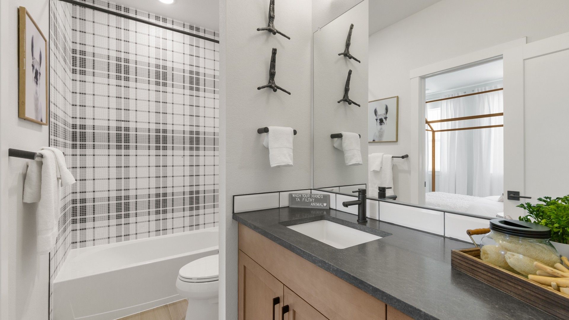 Elegant black plaid tiles and exquisite wood vanity highlight Dillon Pointe's chic bathroom design.