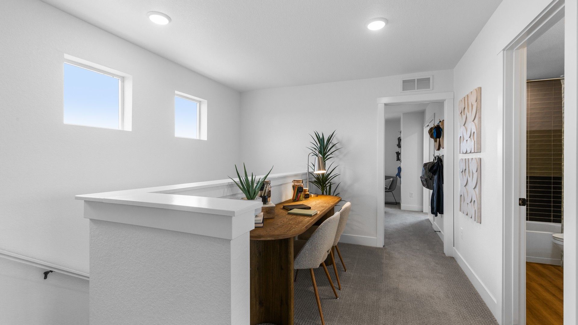 Elegant wooden desk and plush seating highlight this minimalist office space in Bloom community.