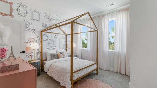 Elegant canopy bed accents the bedroom's artistic walls and airy windows in Dillon Pointe.