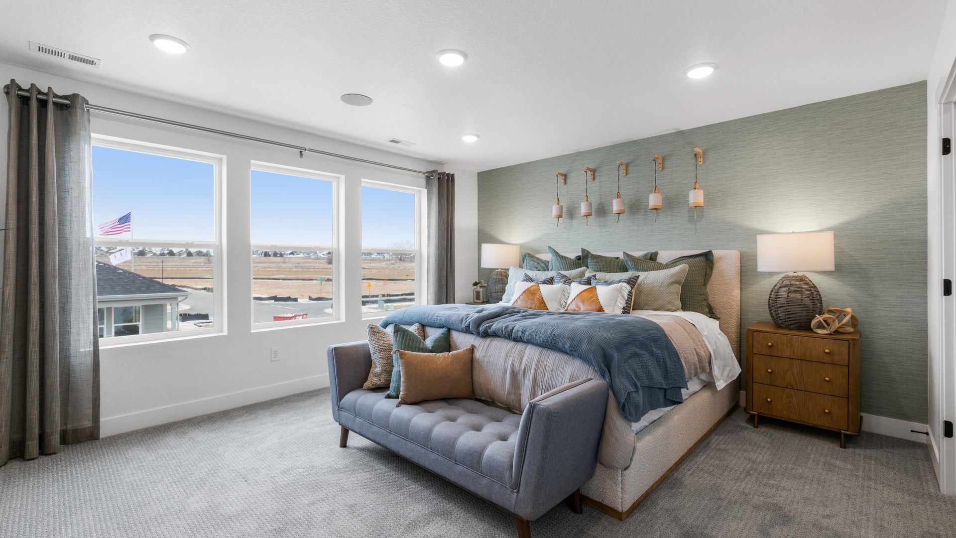 Spacious bedroom in Bloom, featuring panoramic windows, plush carpet, and elegant lighting accents.