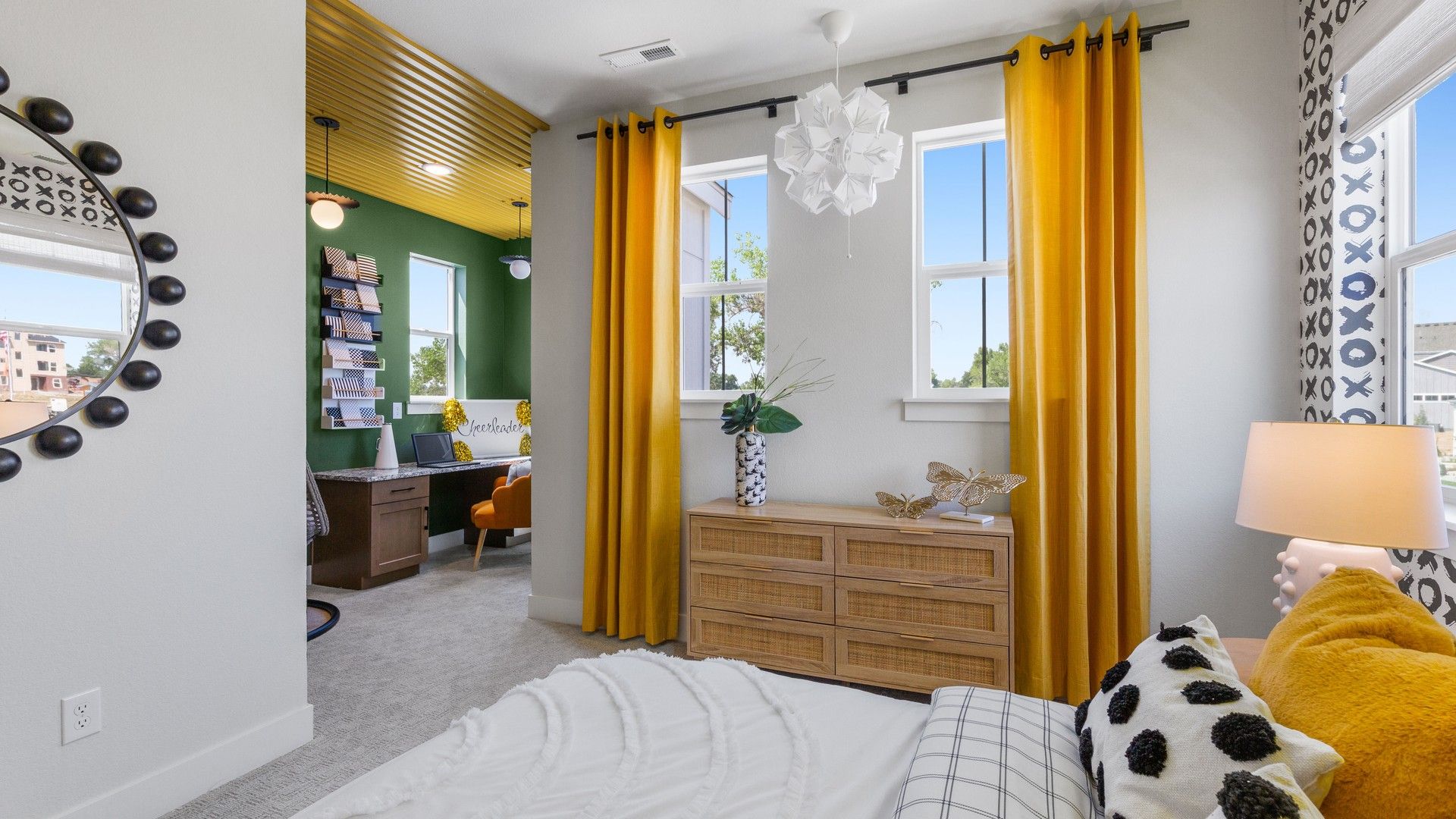 Exquisite bedroom featuring plush decor, standout mustard curtain, sleek rattan dresser in Dillon Pointe.