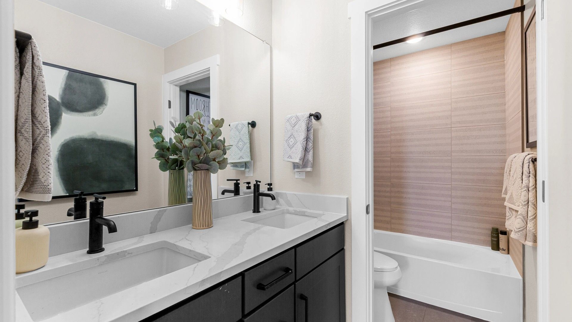 Exquisite bathroom features dual marble sinks, chic black fixtures, and sleek modern design, Timnath Lakes.
