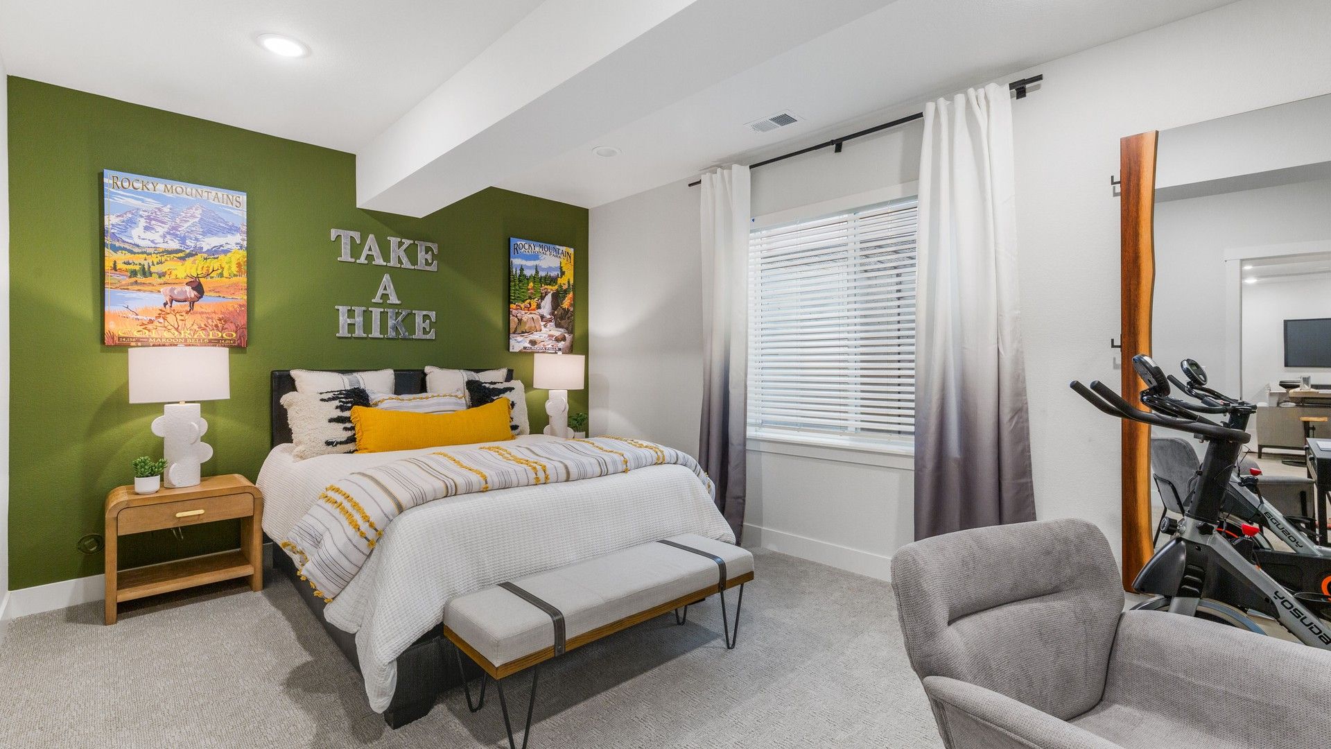 Elegant bedroom with olive accent wall and cozy decor in Dillon Pointe offers refined comfort.