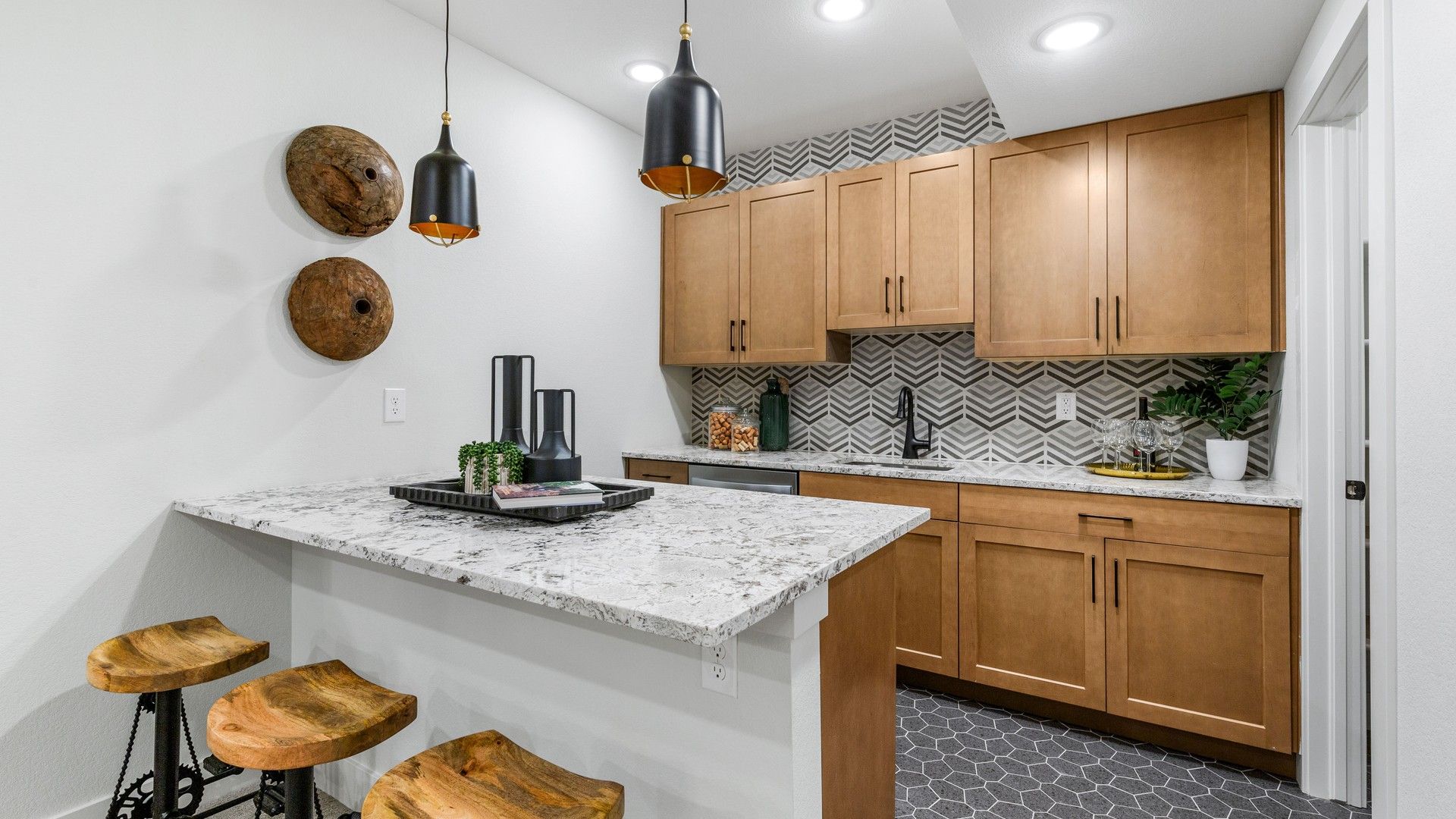 Elegant kitchen with bespoke wood cabinetry and premium herringbone tiles in Dillon Pointe, showcasing refined design.