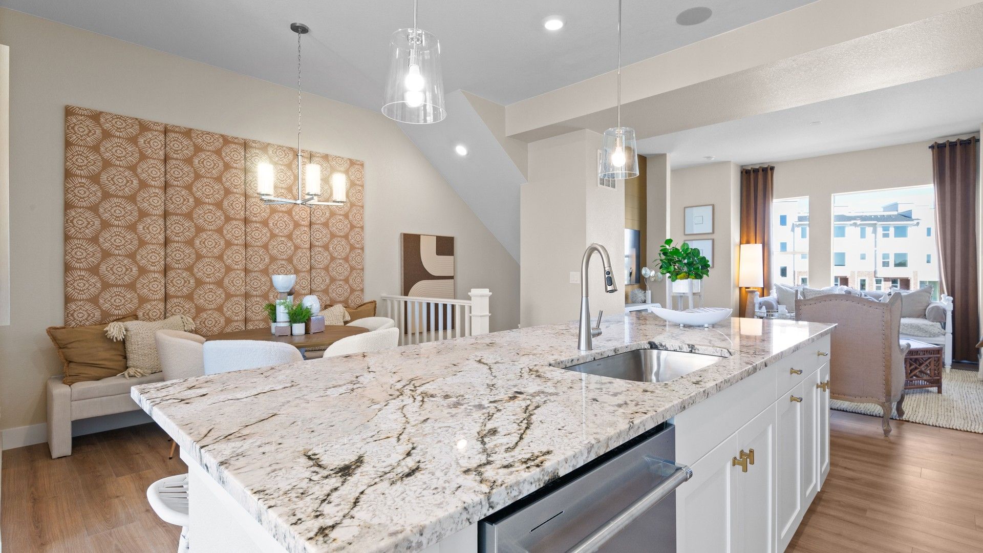Polished granite island and stylish pendant lighting elevate this Dillon Pointe kitchen's elegance.