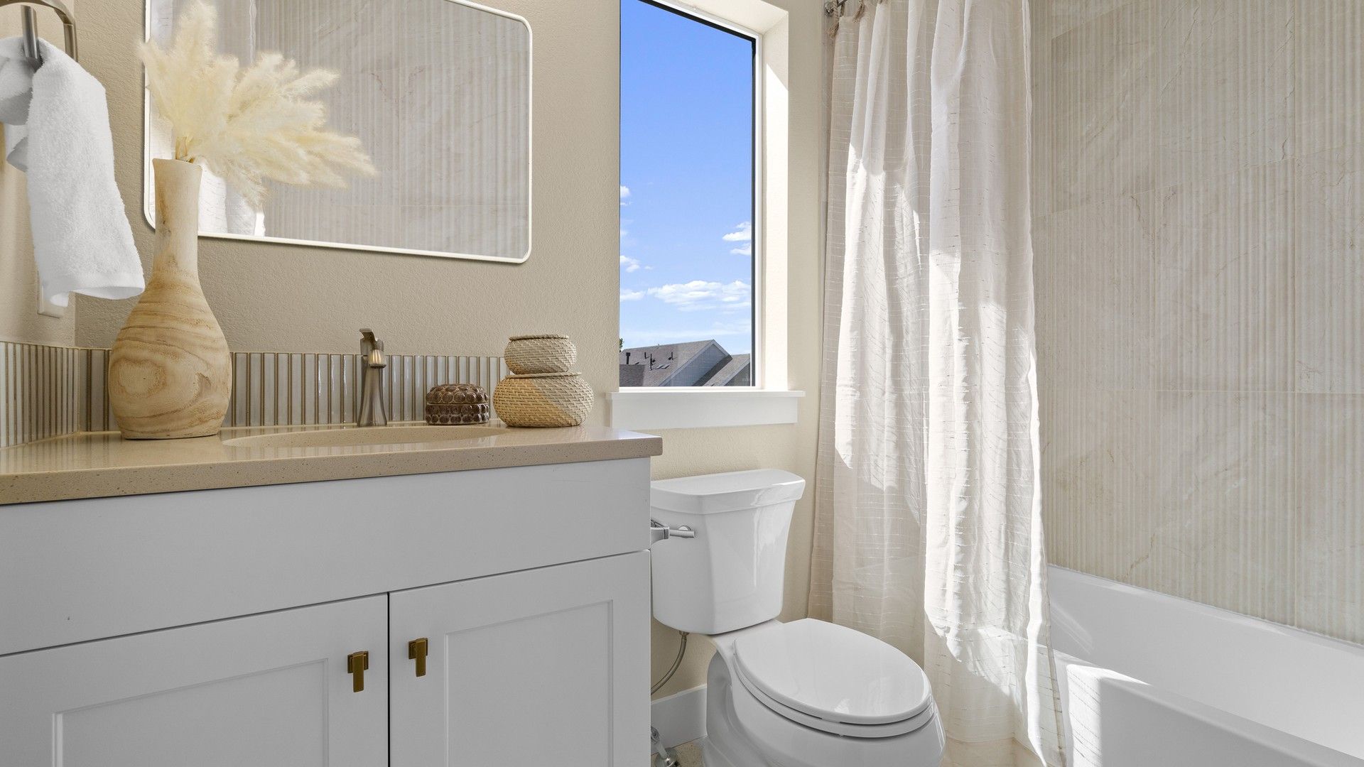 Elegant bathroom features upscale beige tiles, refined fixtures, and ample natural light in Dillon Pointe.