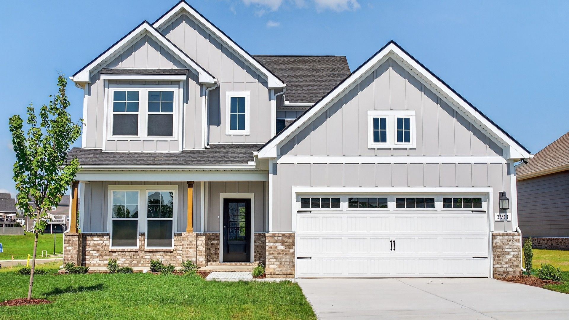 Elegant gabled roof and gray siding complement the brickwork in Oakland's prestigious McClure Farms.