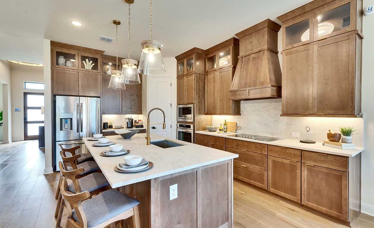 Exquisite wood cabinetry and luxe pendant lighting set a sophisticated tone in this San Gabriel kitchen.