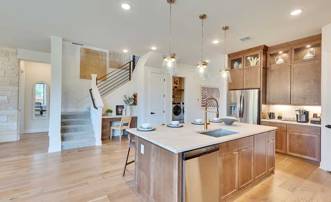 Elegant wood cabinetry and sleek pendant lighting define this chic San Gabriel kitchen.