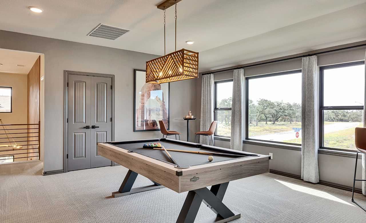 Luxurious game room features sleek pool table, panoramic windows, and chic lighting in Retreat at San Gabriel.