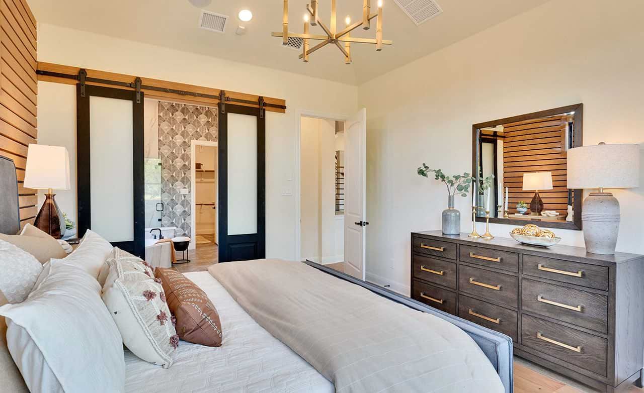 Elegant barn doors and designer lighting define this upscale bedroom at Retreat at San Gabriel.