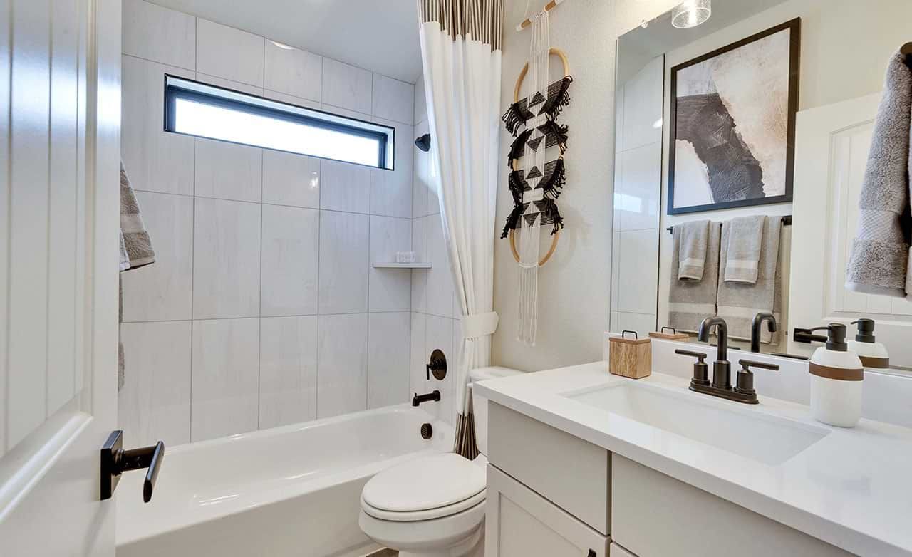 Elegantly tiled bathroom with high-end fixtures and contemporary art at Retreat at San Gabriel.