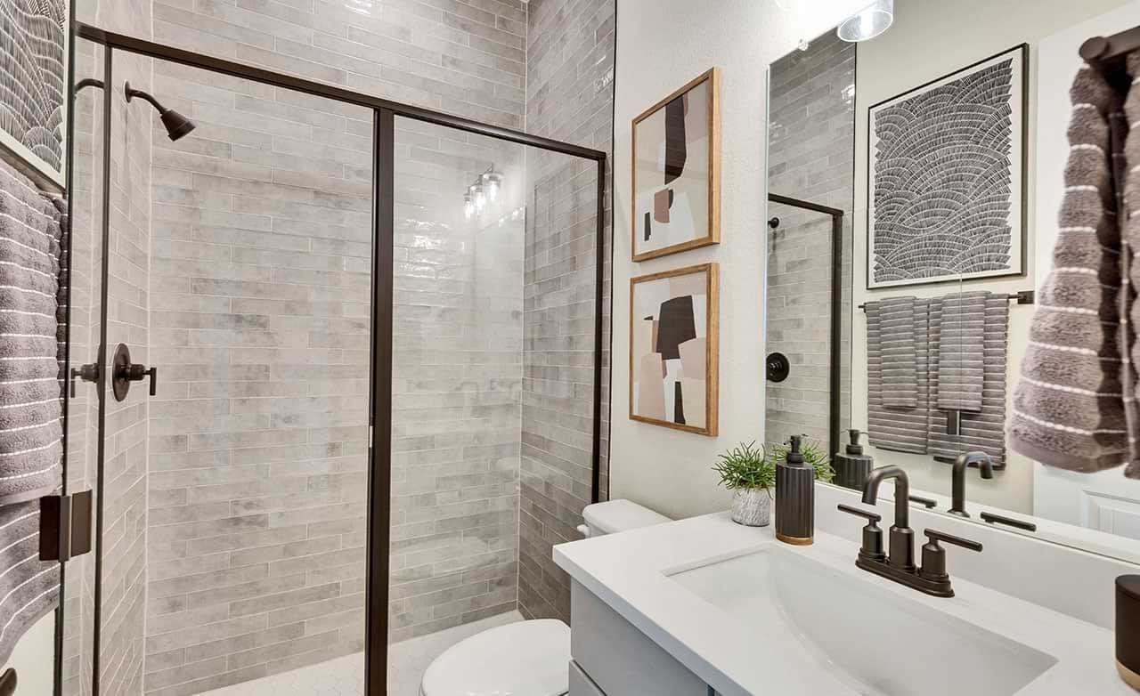 Luxurious gray tile walls and sleek fixtures define this elegant San Gabriel bathroom.