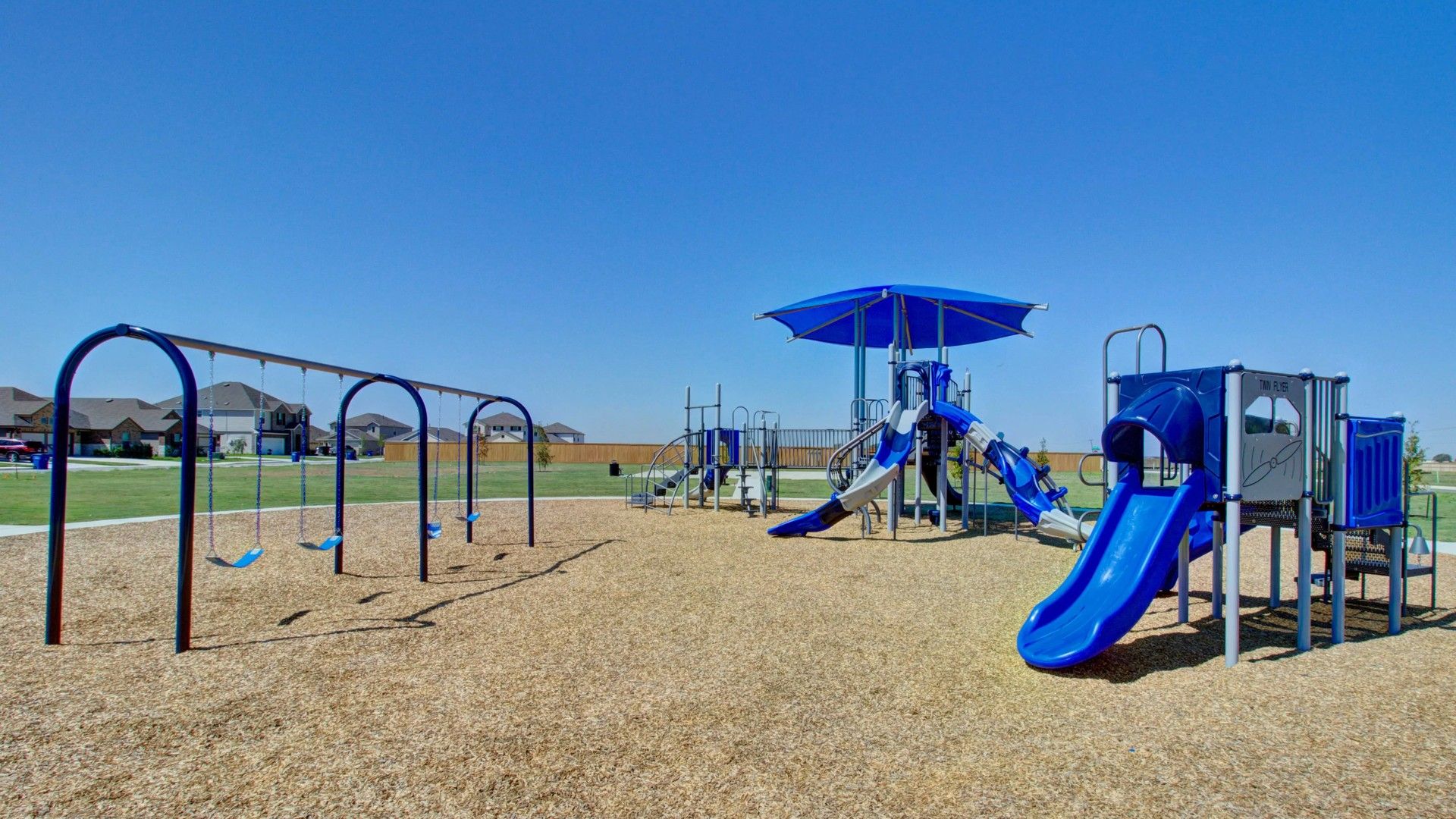 Discover modern outdoor play structures with vibrant slides in Dauer Ranch, surrounded by serene suburban settings.