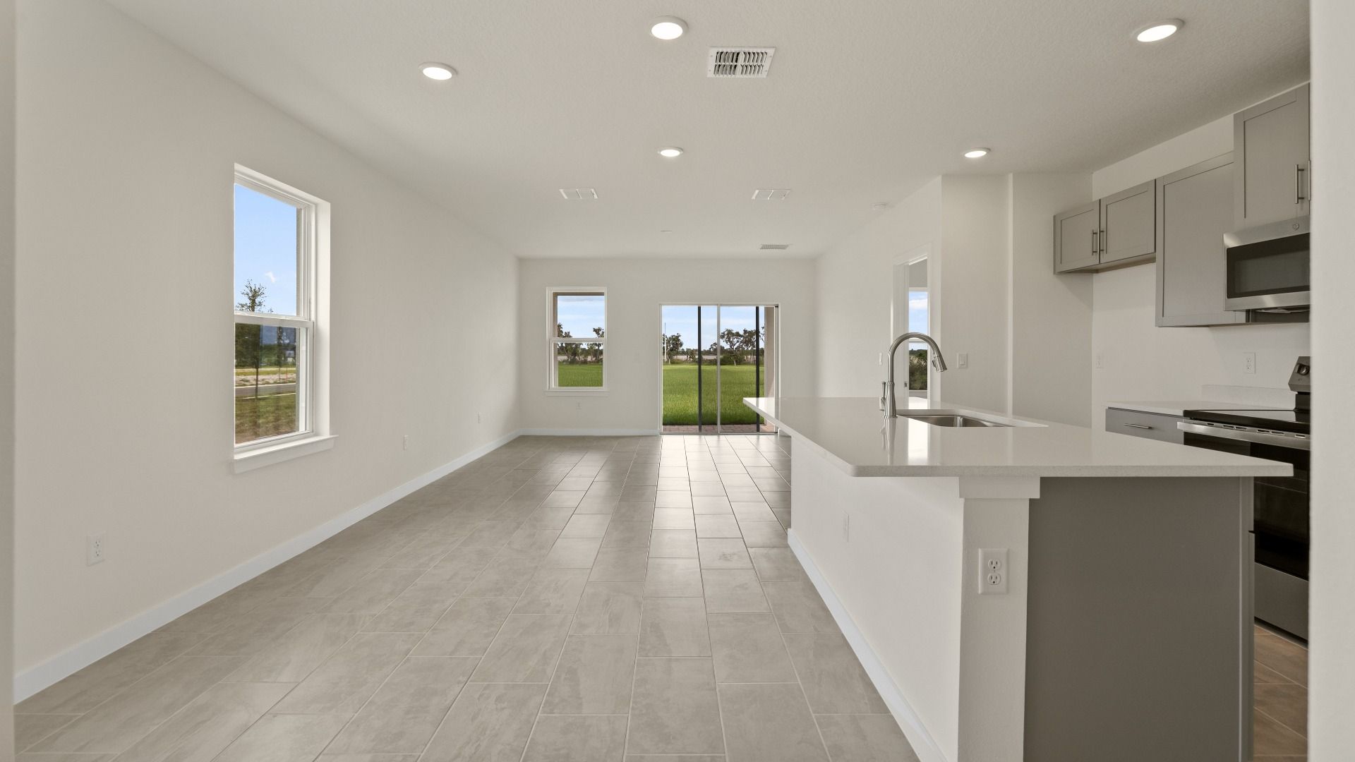 The Naples Living Room and Kitchen Island Quick Move-In Home at Willowbrook North by DRB Homes in Winter Haven, FL