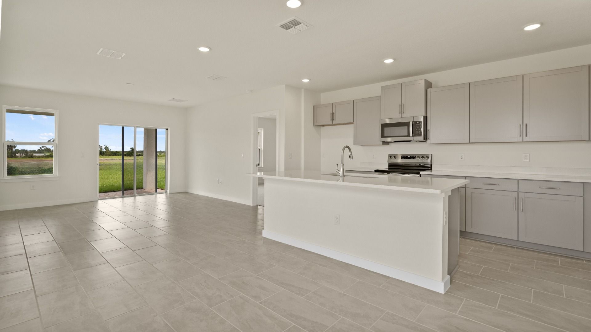 The Naples Living Room and Kitchen Island Quick Move-In Home at Willowbrook North by DRB Homes in Winter Haven, FL