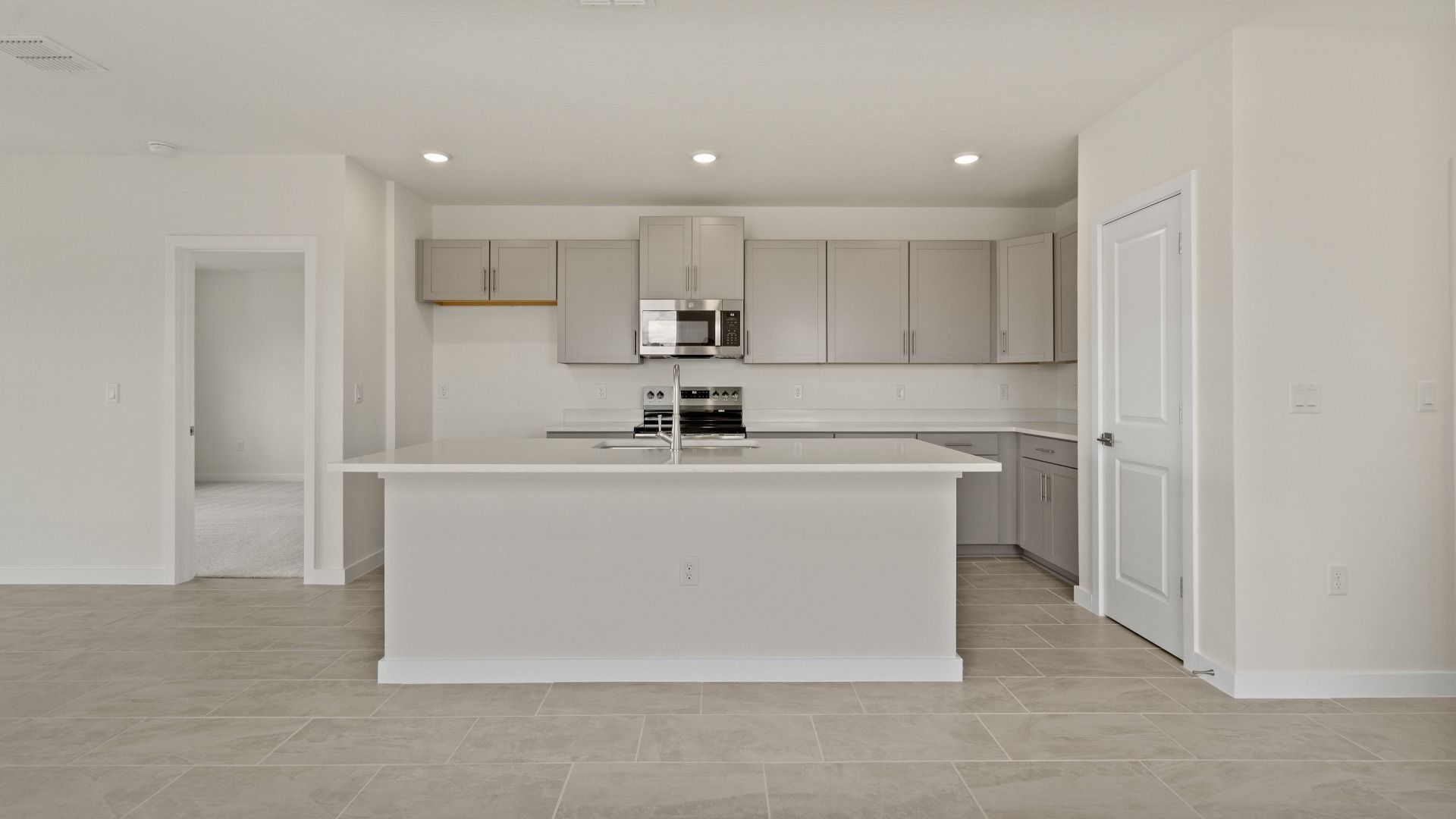 The Naples Kitchen with large Island Quick Move-In Home at Willowbrook North by DRB Homes in Winter Haven, FL