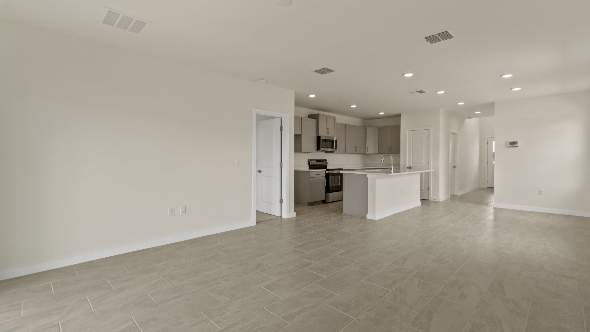 The Naples Living Area and Kitchen with large Island Quick Move-In Home at Willowbrook North by DRB Homes in Winter Haven, FL