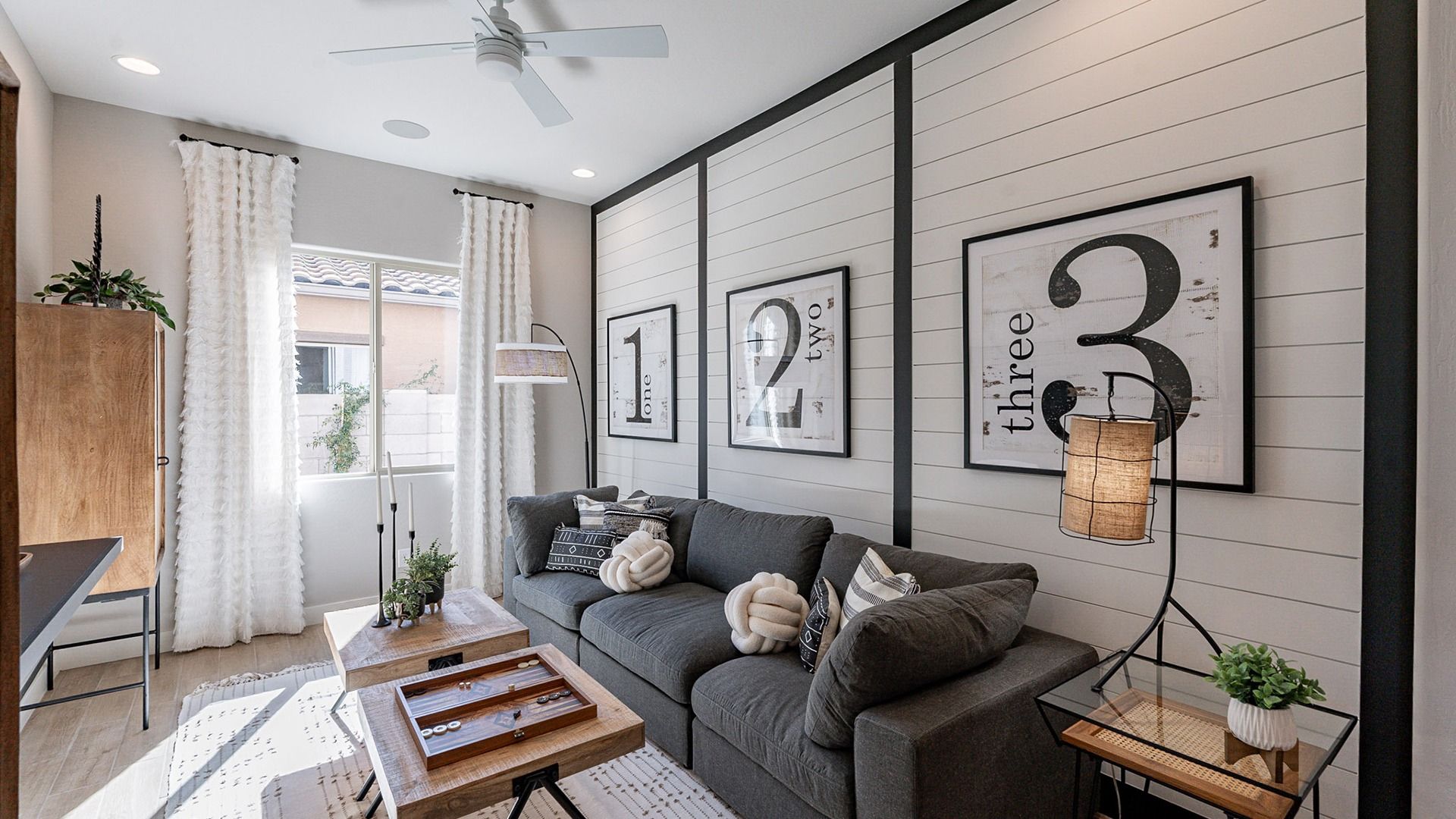 Elegant shiplap walls, plush grey sofa, and sleek wood accents define this Arroyo Seco Hacienda retreat.