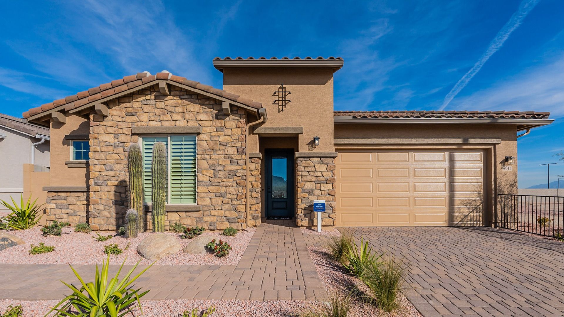Elegant stone facade and desert landscaping in Arroyo Seco. Tiled roof adds timeless luxury.