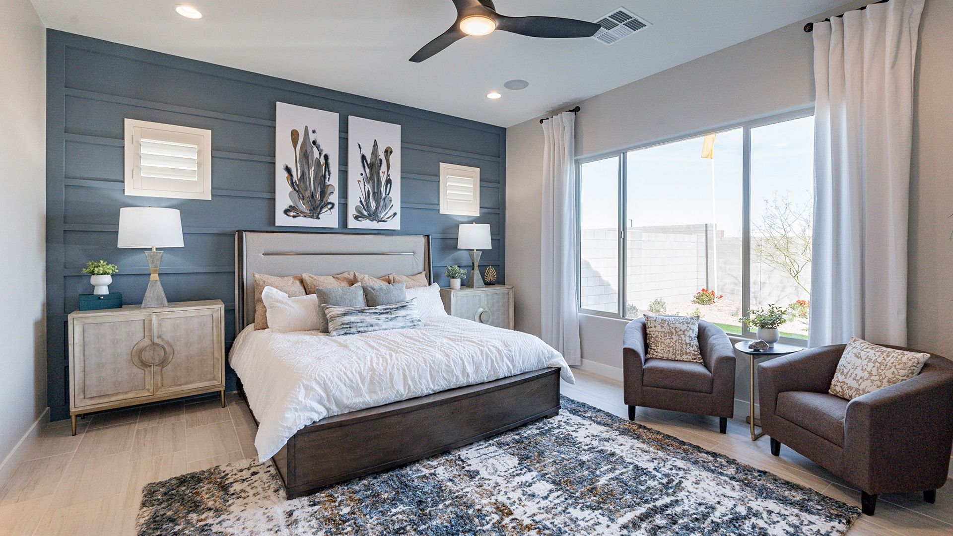 Luxurious bedroom featuring a bold accent wall, chic ceiling fan, and ample natural light in Arroyo Seco.