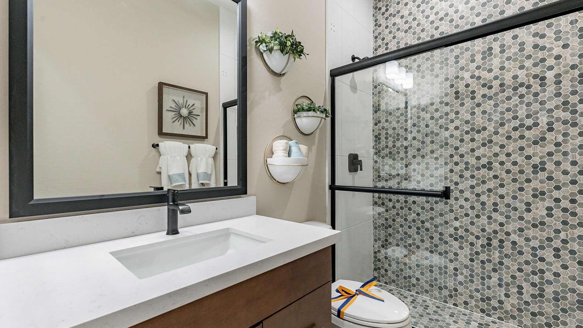 This elegant bathroom in Arroyo Seco features distinctive hexagonal tiles and chic modern fixtures.