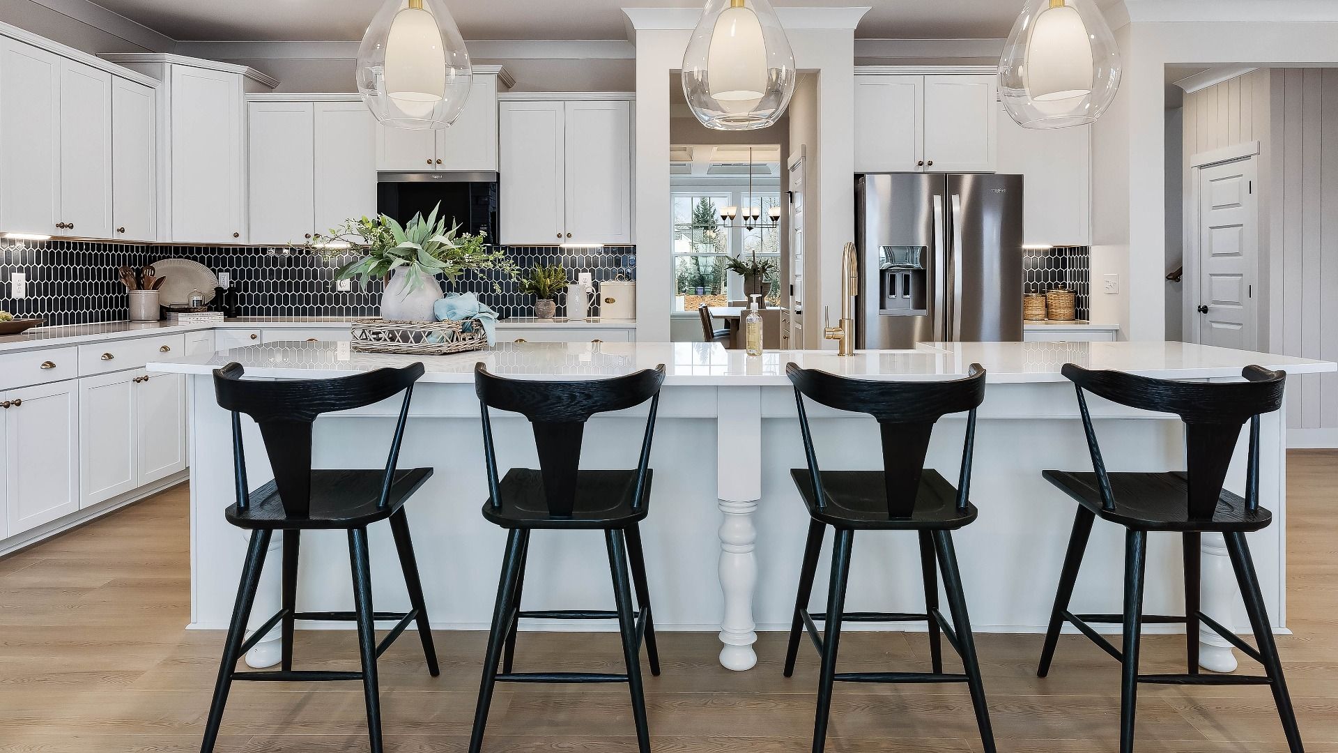 Stonefield home plan open concept kitchen with massive island and abundant cabinetry overlooking the family room/breakfast