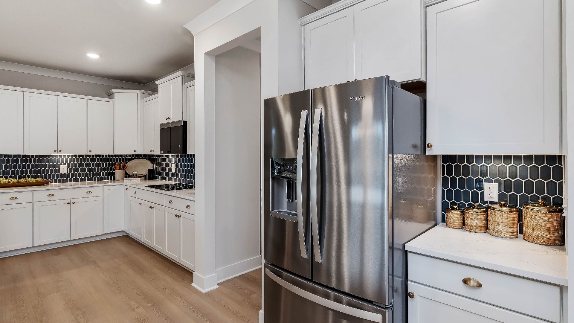 Stonefield home plan open concept kitchen with massive island and abundant cabinetry overlooking the family room/breakfast