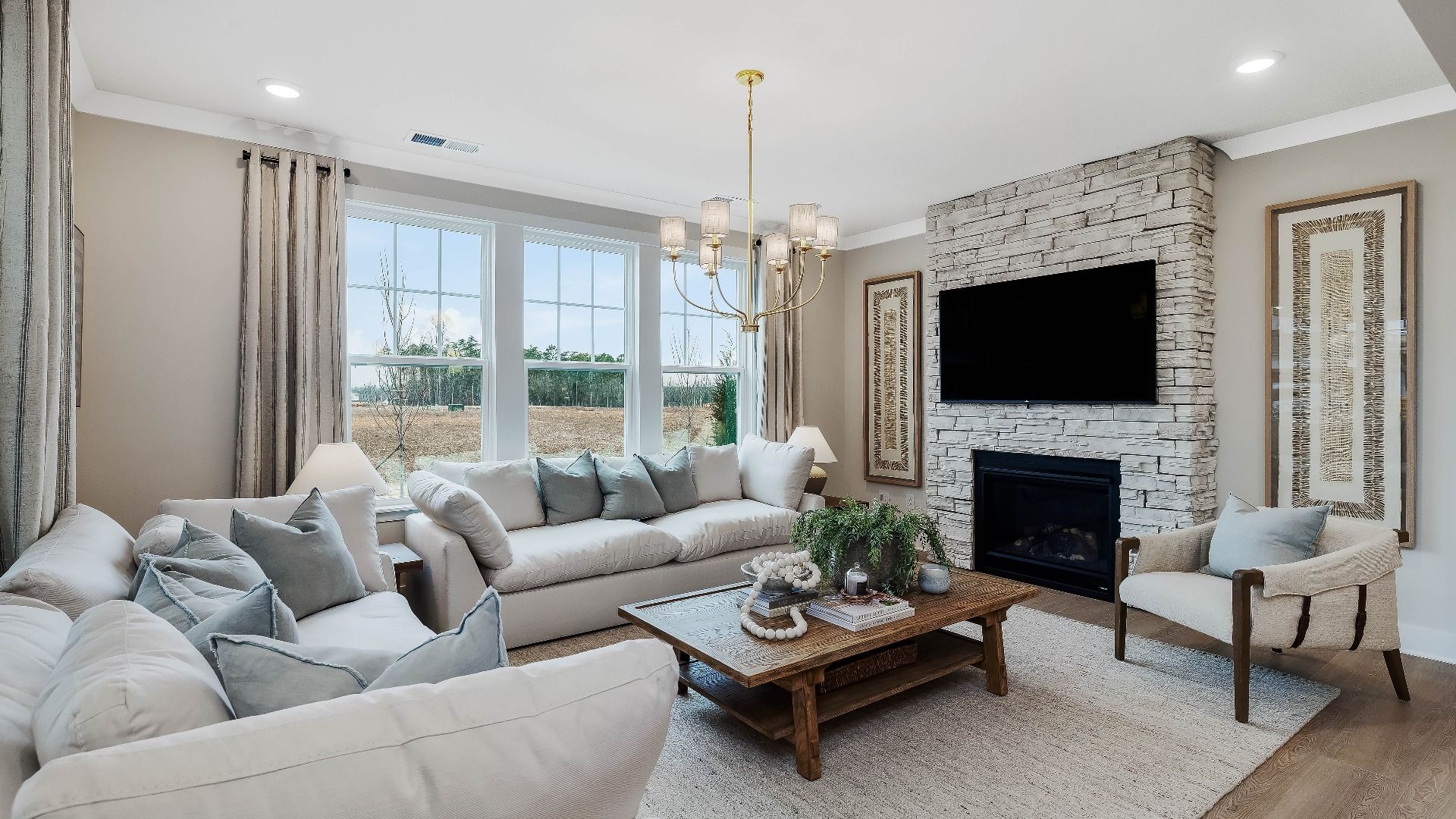 Stonefield home plan open concept family room with stone fireplace and lots of windows