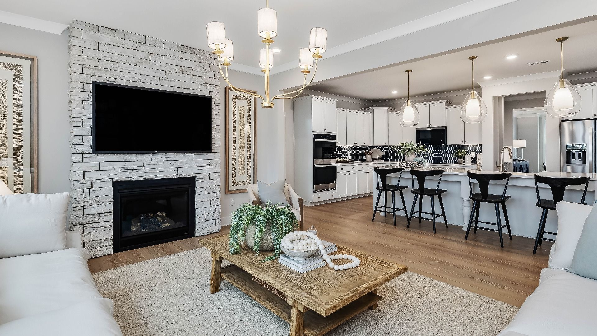 Stonefield home plan open concept family room with stone fireplace and lots of windows