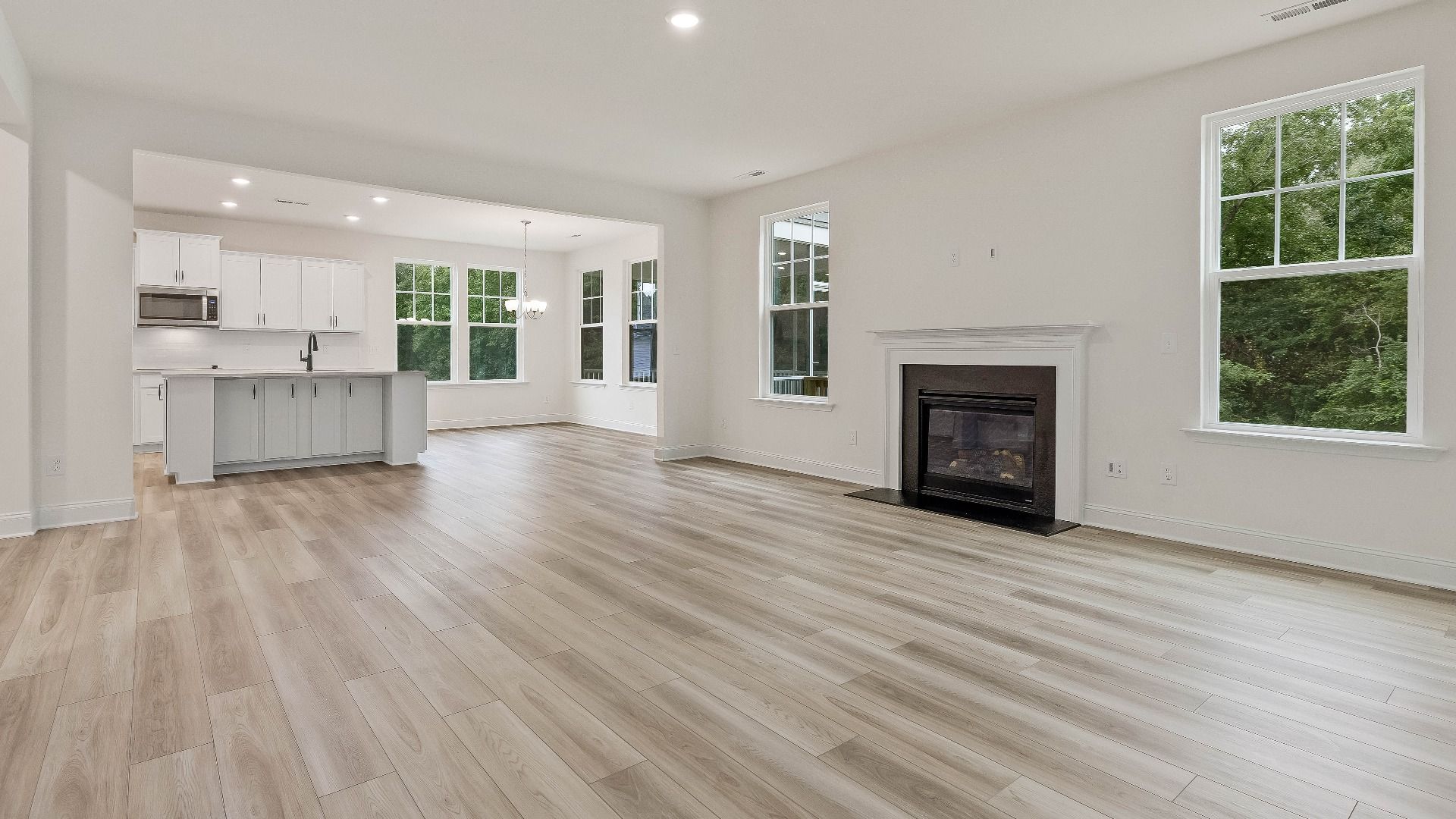 Stonehaven home plan family room/living space with fireplace connecting to kitchen and breakfast area