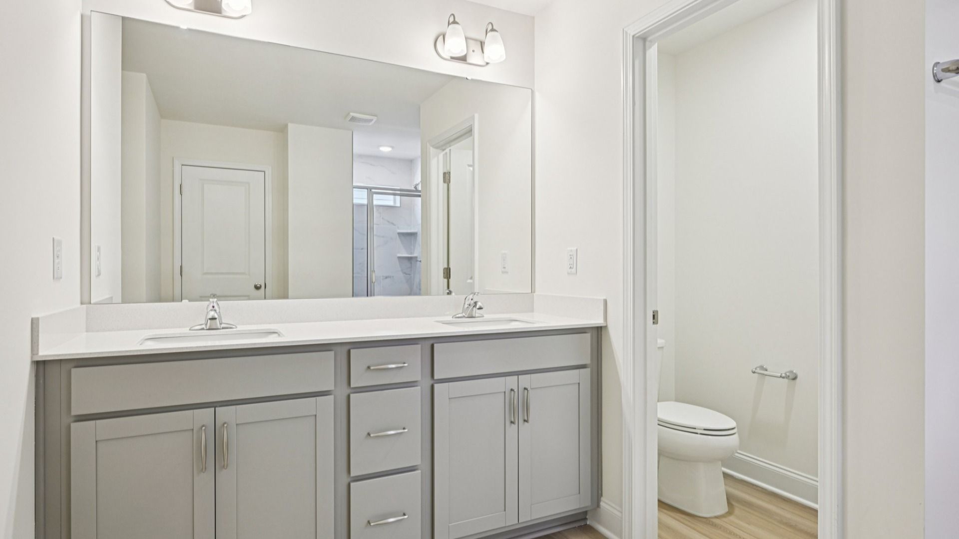 Wagener home plan primary en suite bathroom with dual vanities, toilet room, tile shower