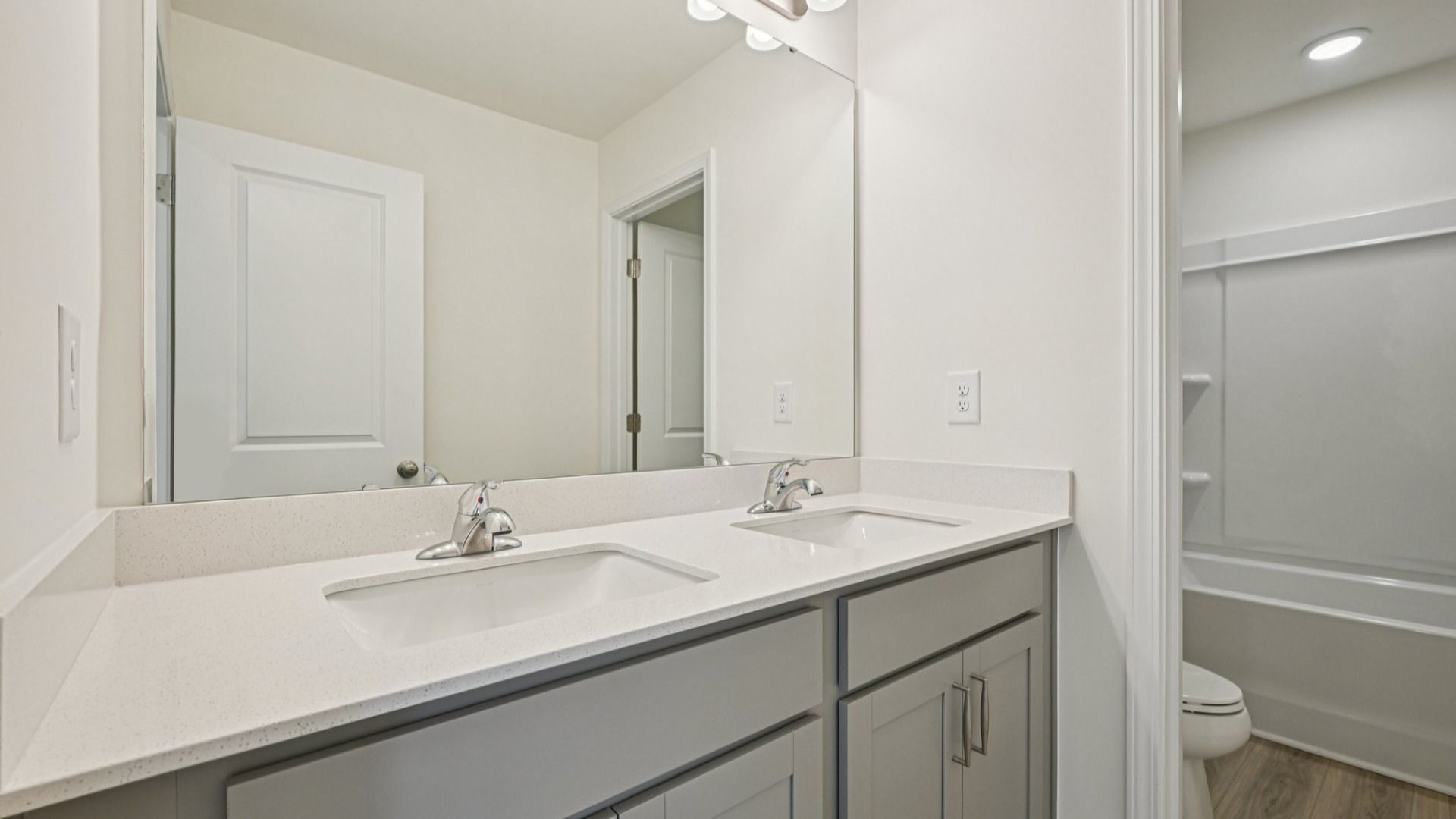 Wagener home plan secondary bathroom with dual vanities, toilet room and shower