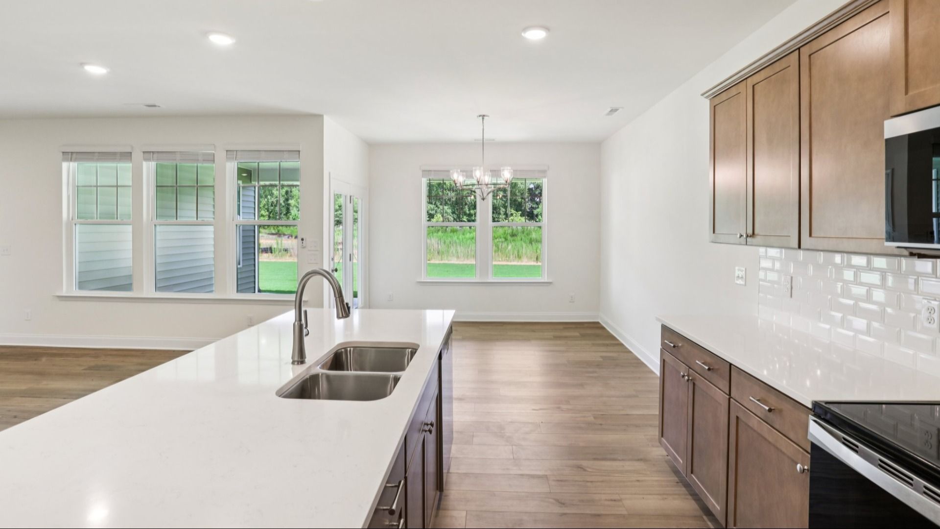Pendleton home plan open concept kitchen with large island and abundant cabinetry overlooking family and breakfast