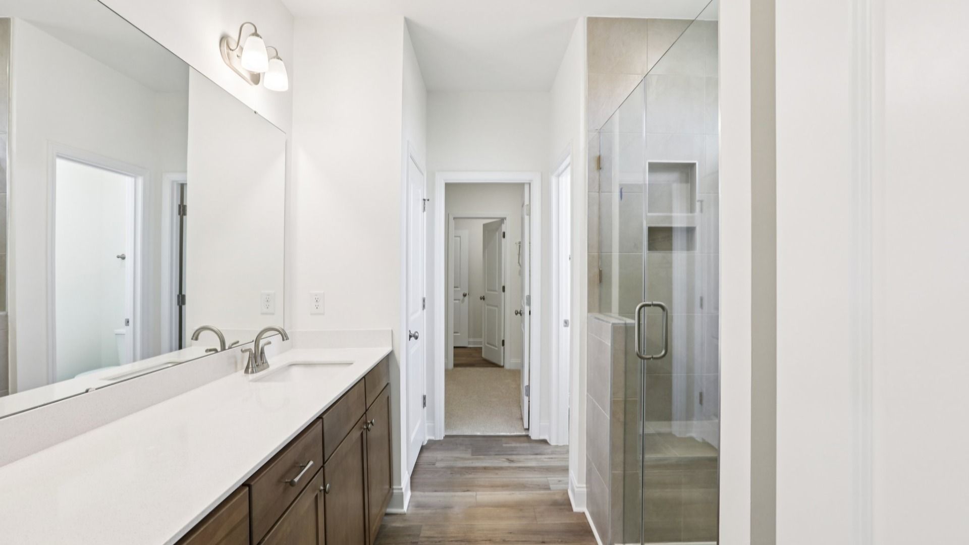 Pendleton home plan primary bathroom with tile shower, dual vanities and linen closet