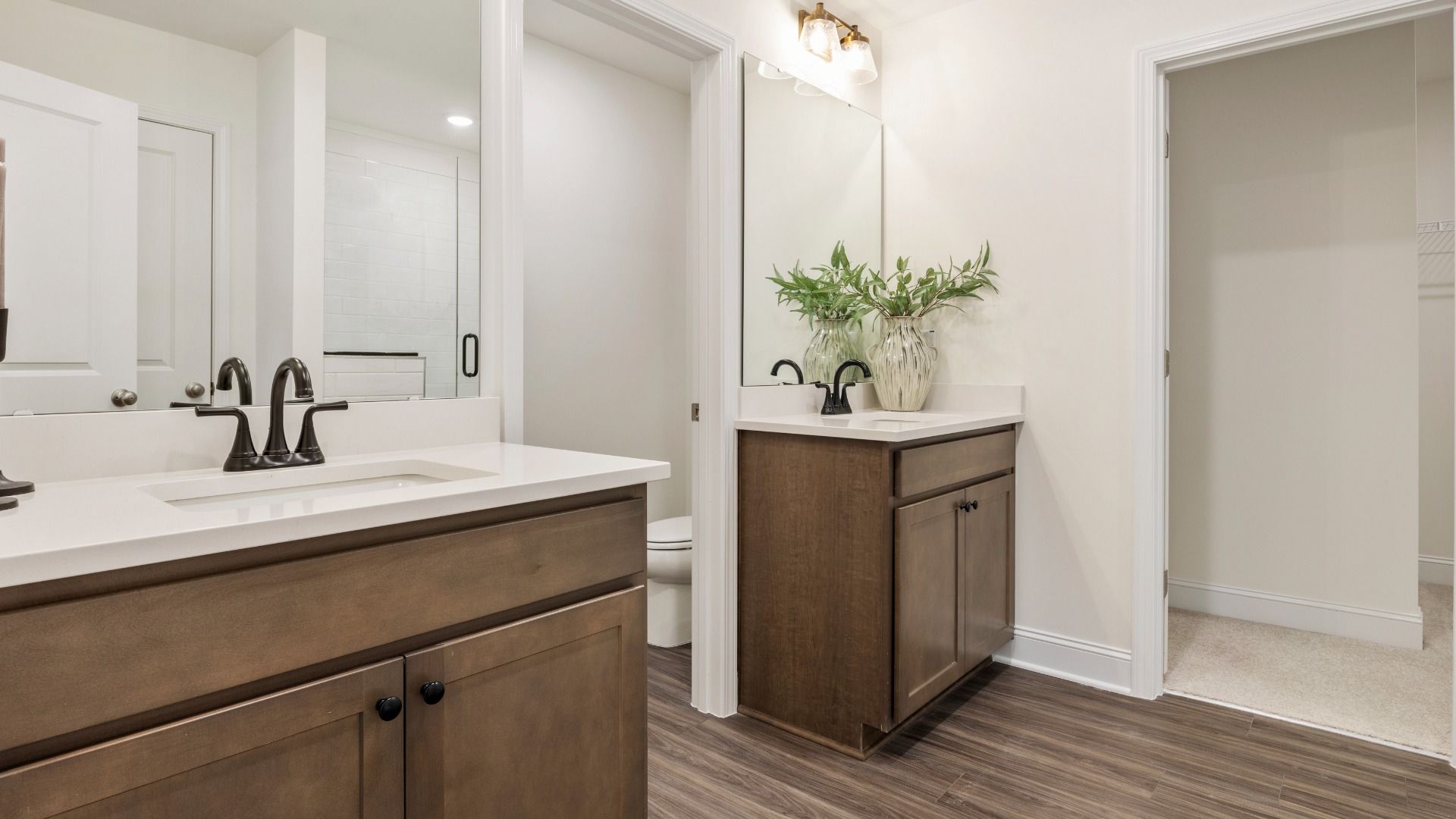 Townsend home plan en suite bathroom with separate vanities, tile shower, and ample closet storage