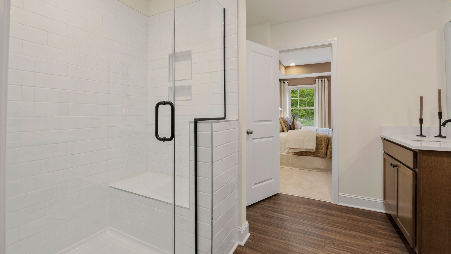 Townsend home plan en suite bathroom with separate vanities, tile shower, and ample closet storage