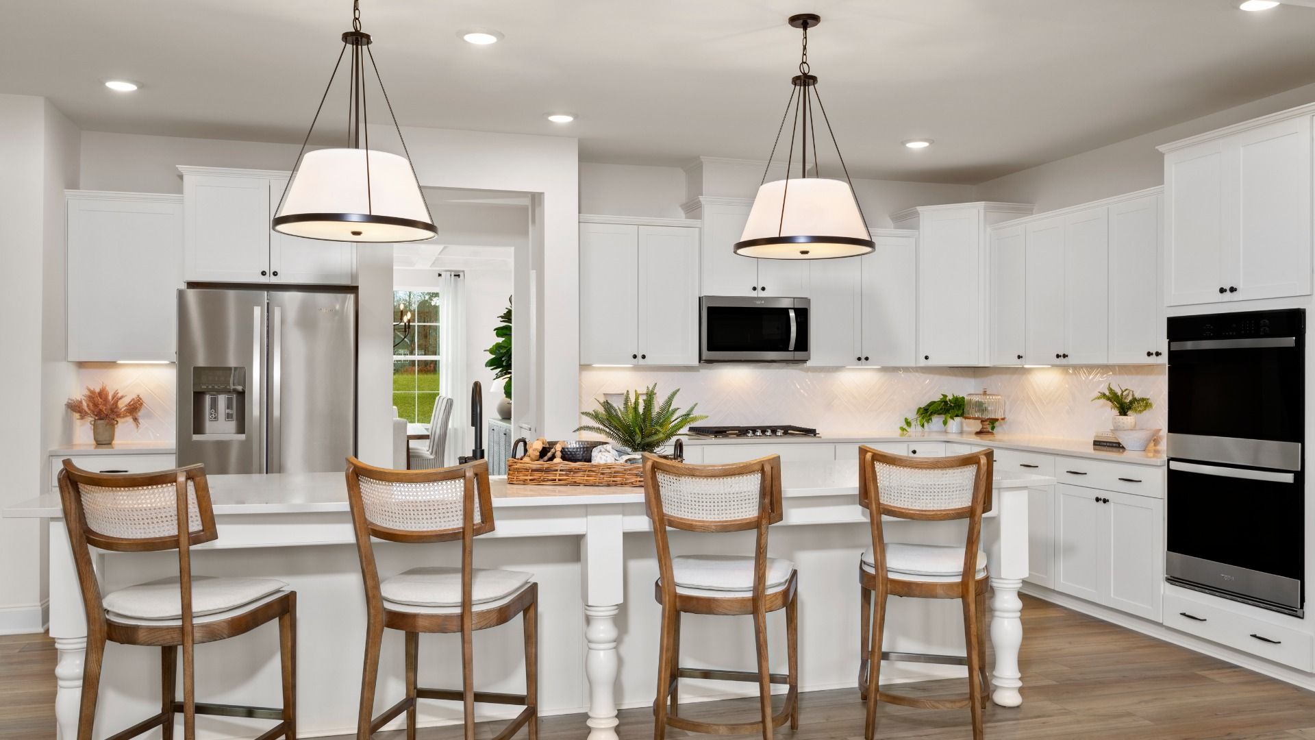 Stonefield home plan open concept kitchen with massive island and abundant cabinetry overlooking the family room/breakfast
