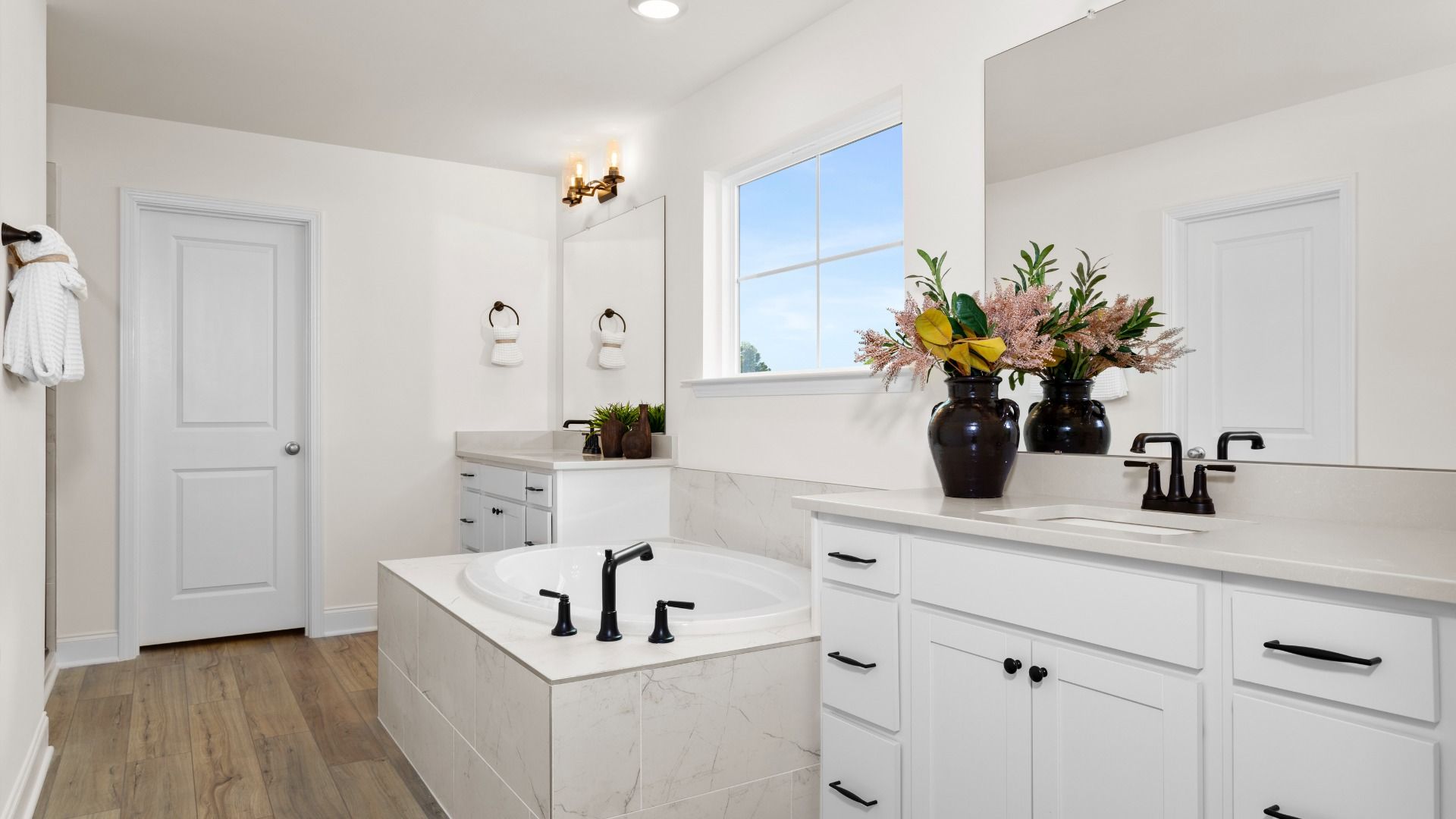Stonefield home plan en suite primary bath with separate vanities, soaking tub and tile shower