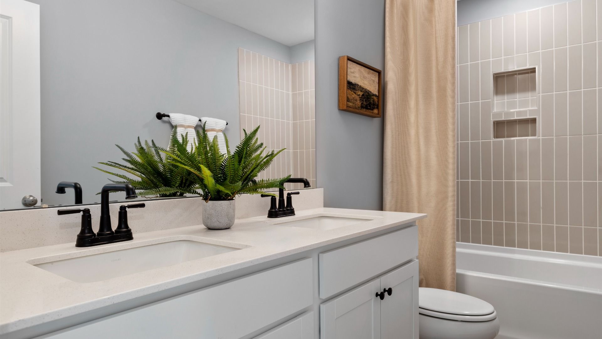 Stonefield home plan secondary bathroom with dual vanities and tile shower