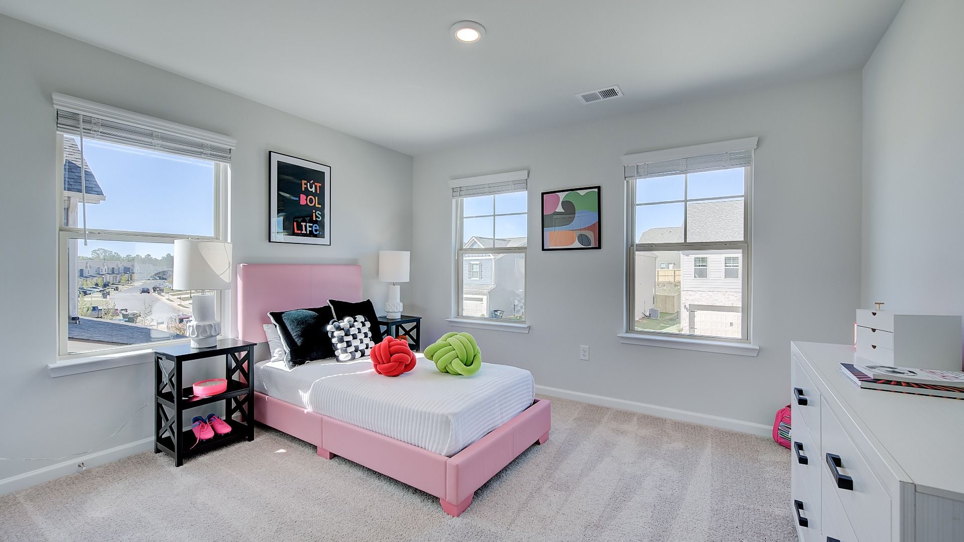 Secondary bedroom in new construction townhome with large windows, natural light, and neutral finishes.