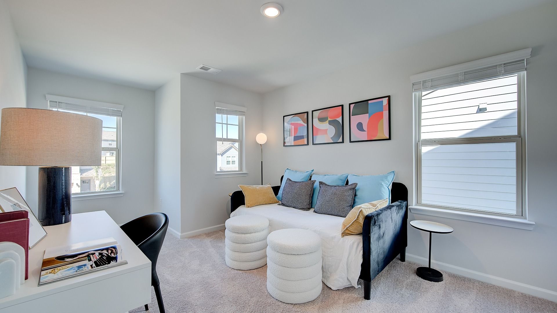 Secondary bedroom in new construction townhome with large windows, natural light, and neutral finishes.