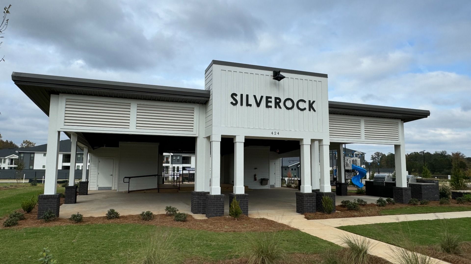 Community pavilion with covered area leading into pool and playground area at Silverock in McDonough, GA.