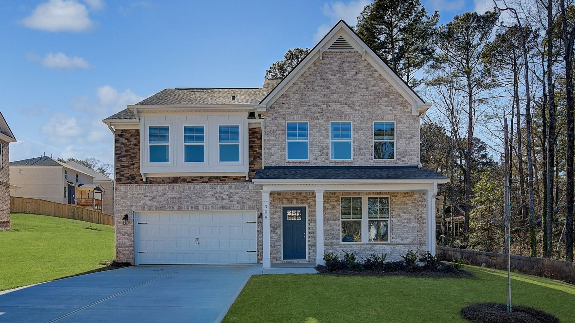 Wagener two-story brick home with stone accent and two-car front-entry garage at Burchwood in Stockbridge, GA.