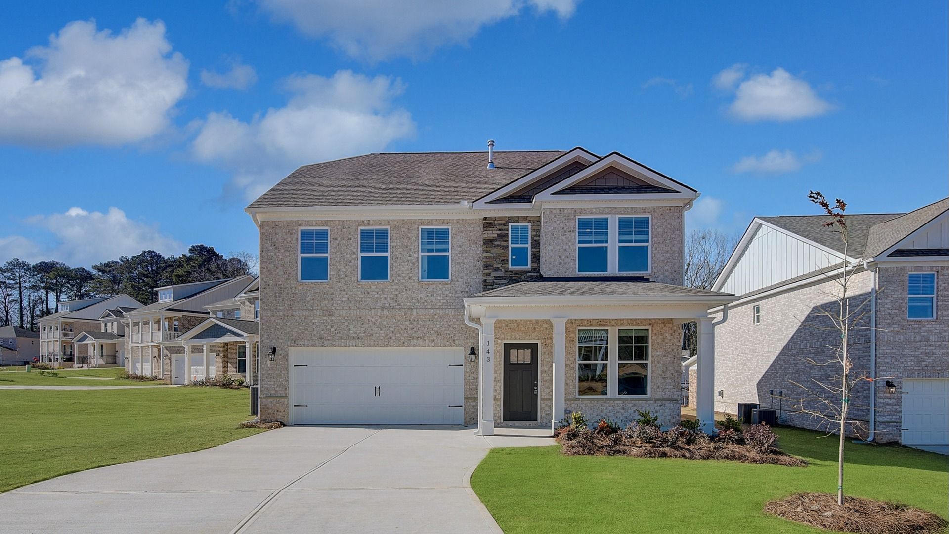Pelham single family home with brick and stone accents, front-entry two-car garage, and spacious yard at Burchwood.