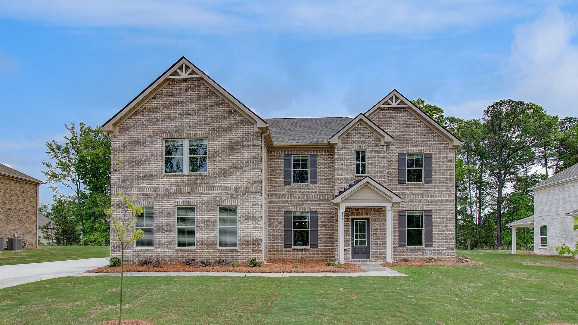 Front exterior of the Mckinley four-sided brick single family home with side entry garage at Cambria at Traditions.