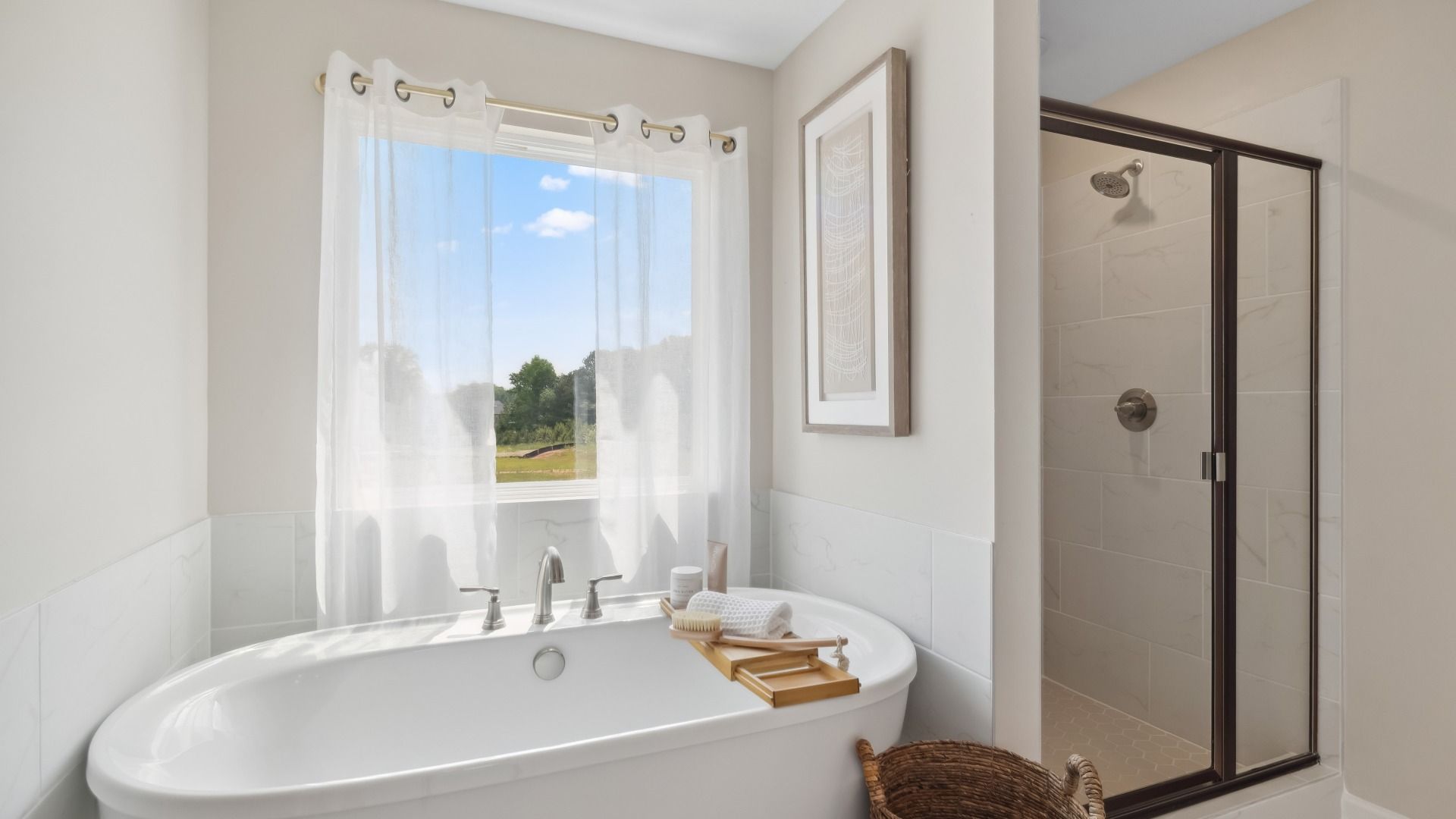 Primary bath with natural light, soaking tub, and walk-in shower with tile finishes at Westwind Estates in Hampton, GA.
